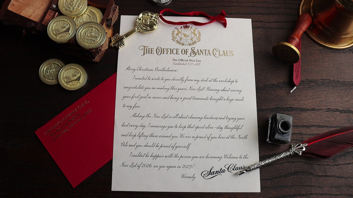 A flat-lay of a vintage-style Santa Claus letter from 'The Office of Santa Claus' on a dark wooden background, surrounded by thematic props including gold coins, a red wax seal, a wooden wax seal stamp, a red ribbon, and a small black camera.